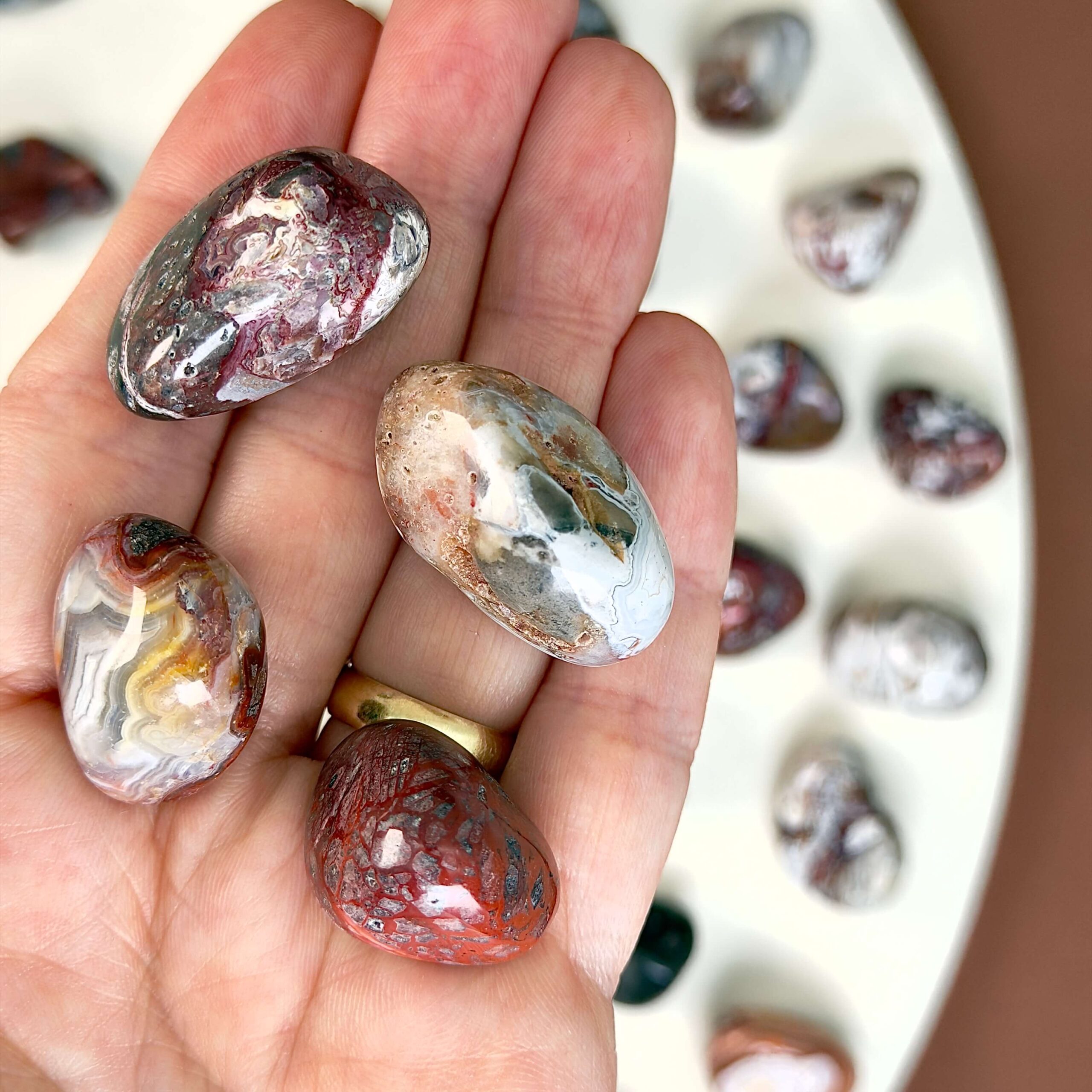 Agat Crazy Lace Lommesten Krystal Sten i hånd på hvid baggrund