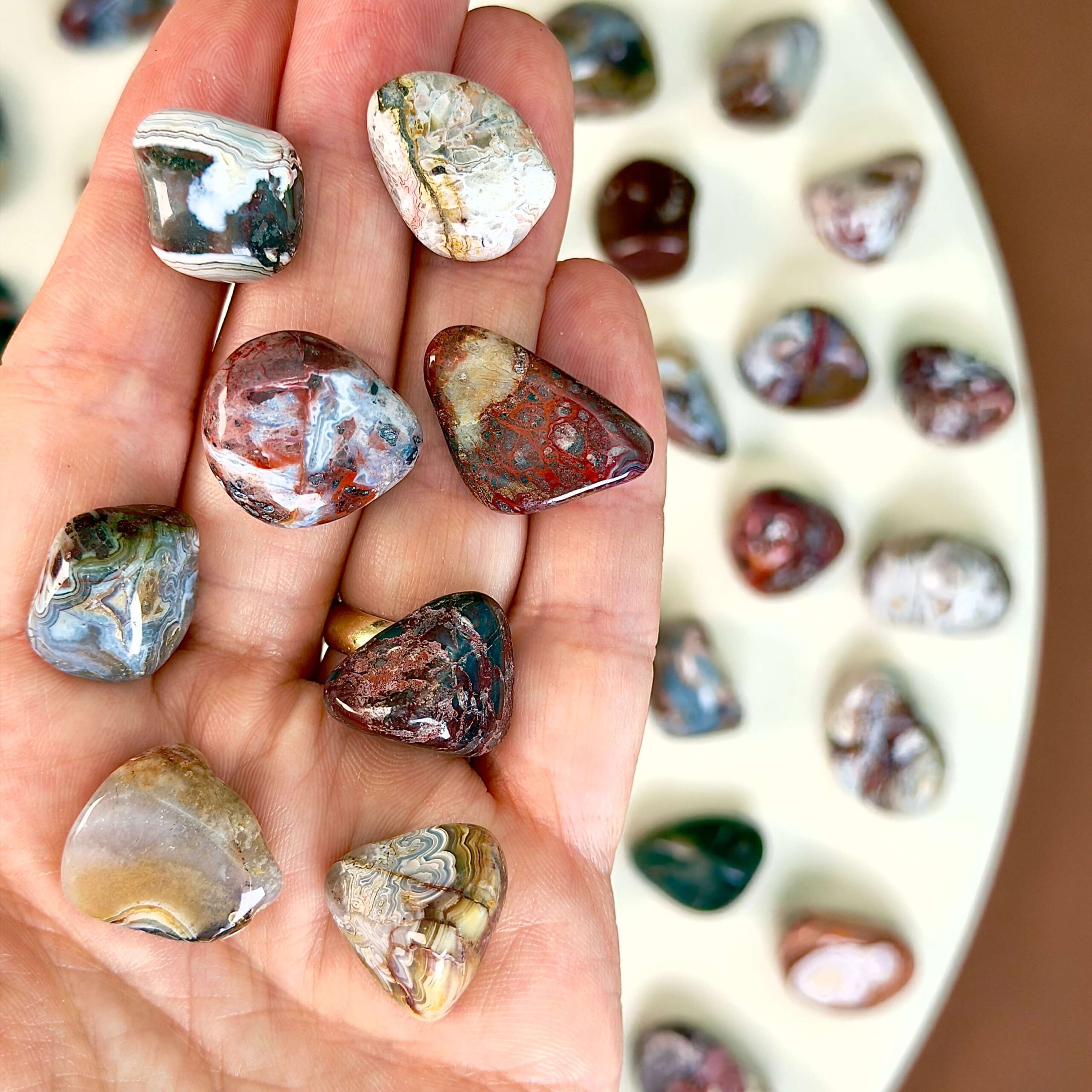 Agat Crazy Lace Lommesten Krystal Sten i hånd på hvid baggrund