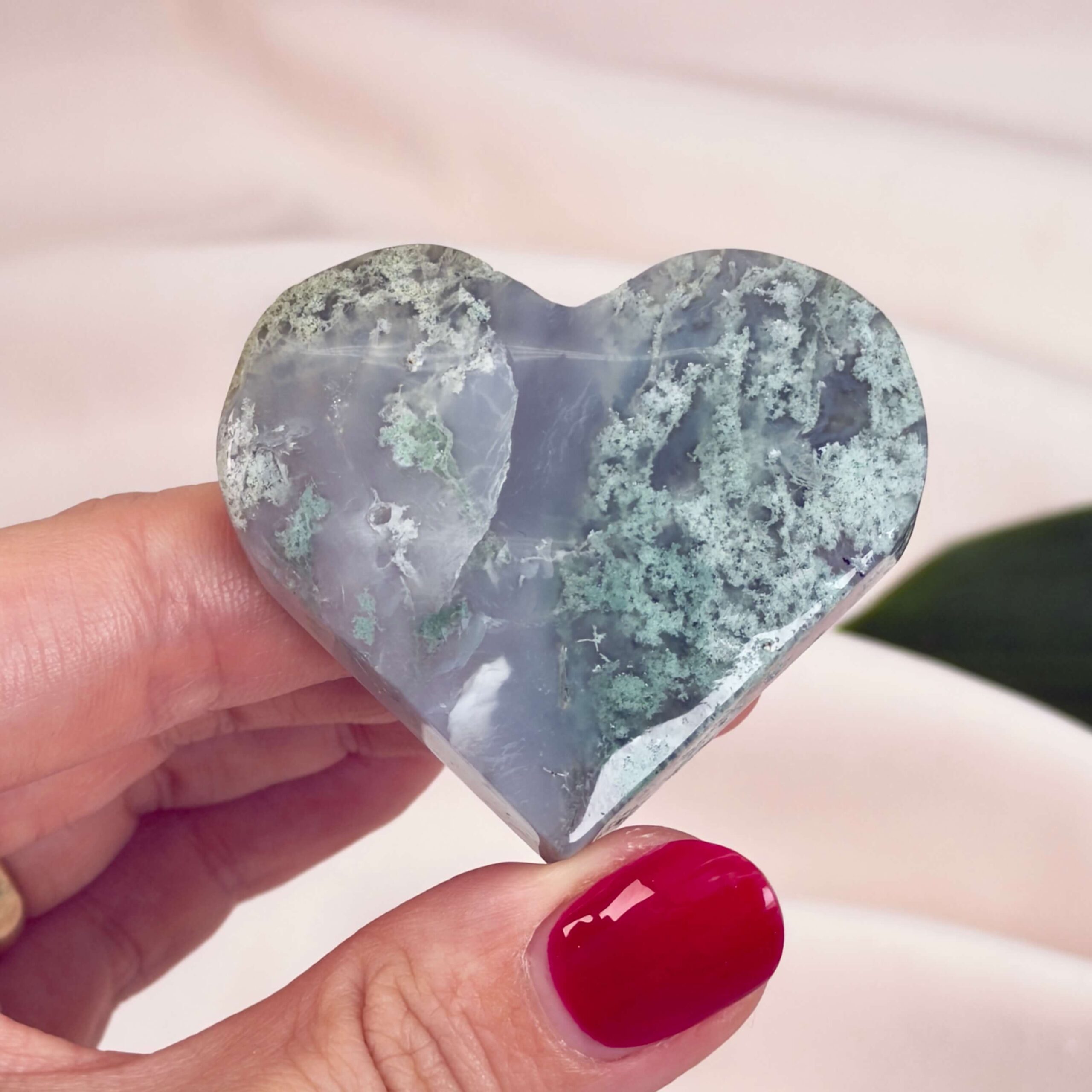 Agat Mos Hjerte Krystal Sten i hånd på hvid baggrund