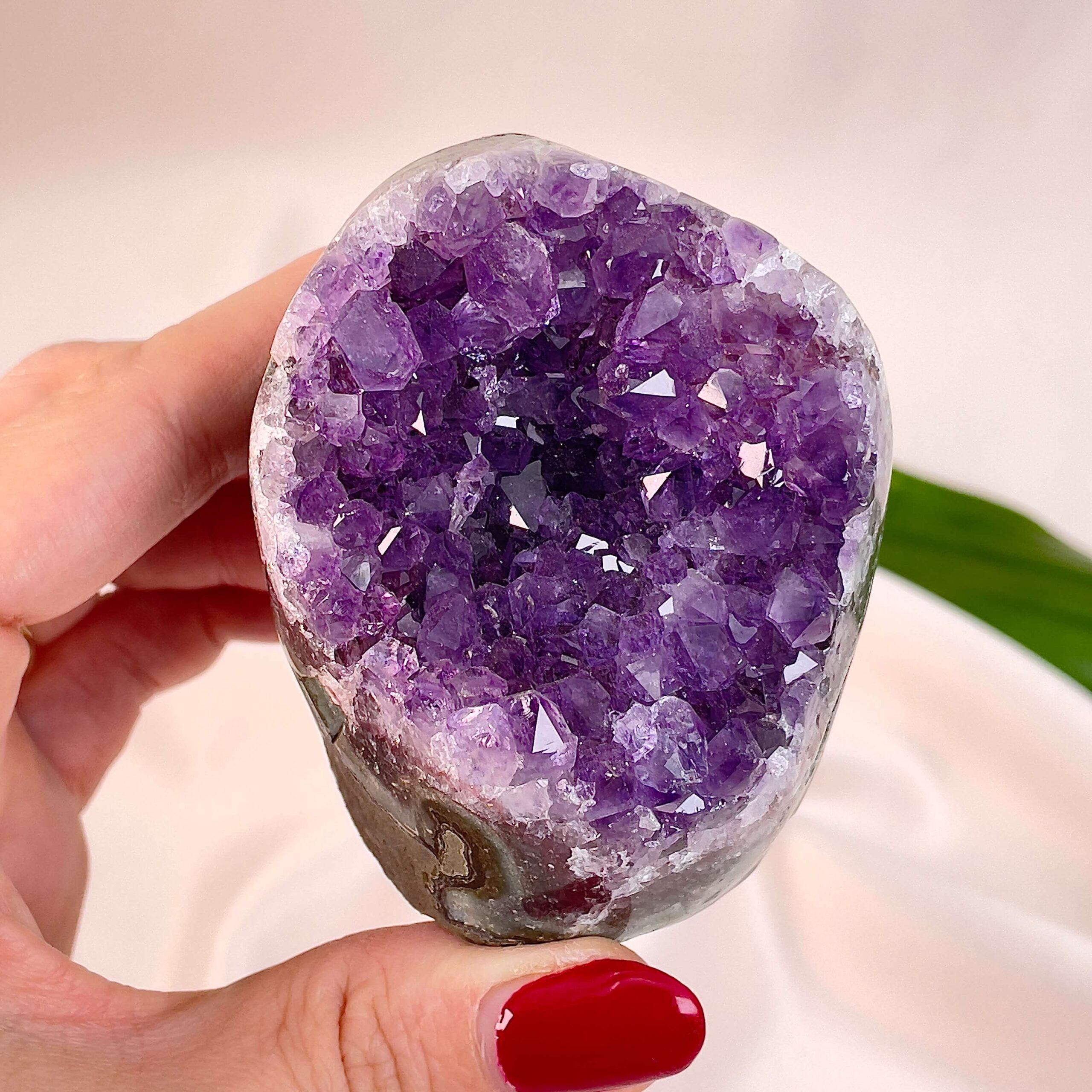 Ametyst Premium Grotte Krystal Sten i hånd på hvid baggrund