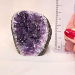 Ametyst Grotte Krystal Sten med lineal i hånd på hvid baggrund