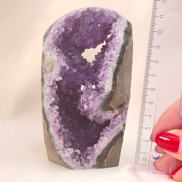 Ametyst Grotte Krystal Sten med lineal i hånd på hvid baggrund