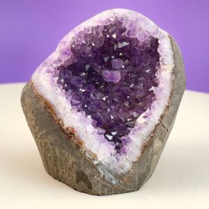 Ametyst Premium Grotte Krystal Sten på Lys og lilla baggrund