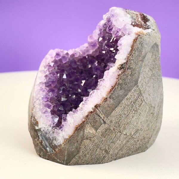 Ametyst Premium Grotte Krystal Sten på Lys og lilla baggrund