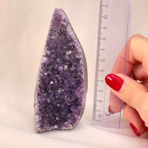 Ametyst Grotte Krystal Sten med lineal i hånd på hvid baggrund