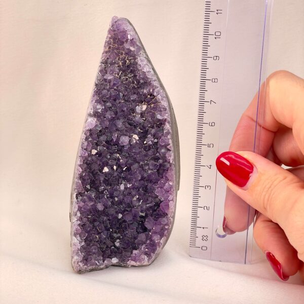 Ametyst Grotte Krystal Sten med lineal i hånd på hvid baggrund