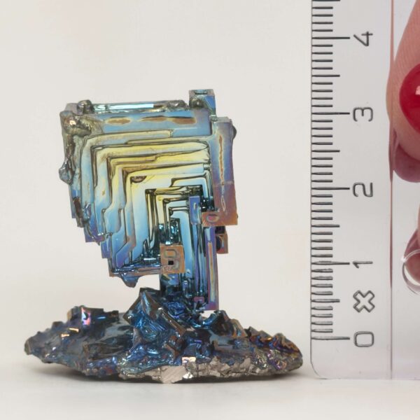 Bismut Rå Krystal Sten med lineal på hvid baggrund