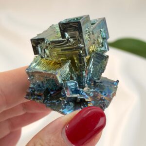 Bismut Rå Krystal Sten i hånd på hvid baggrund