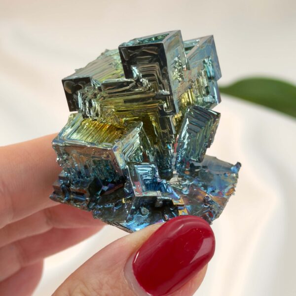 Bismut Rå Krystal Sten i hånd på hvid baggrund