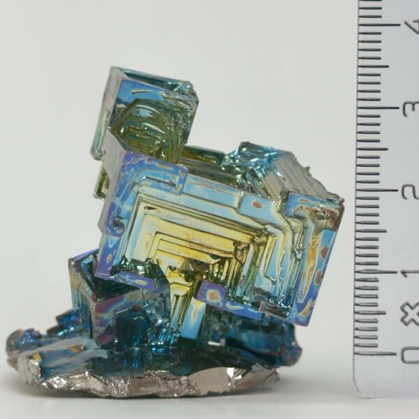 Bismut Rå Krystal Sten med lineal på hvid baggrund