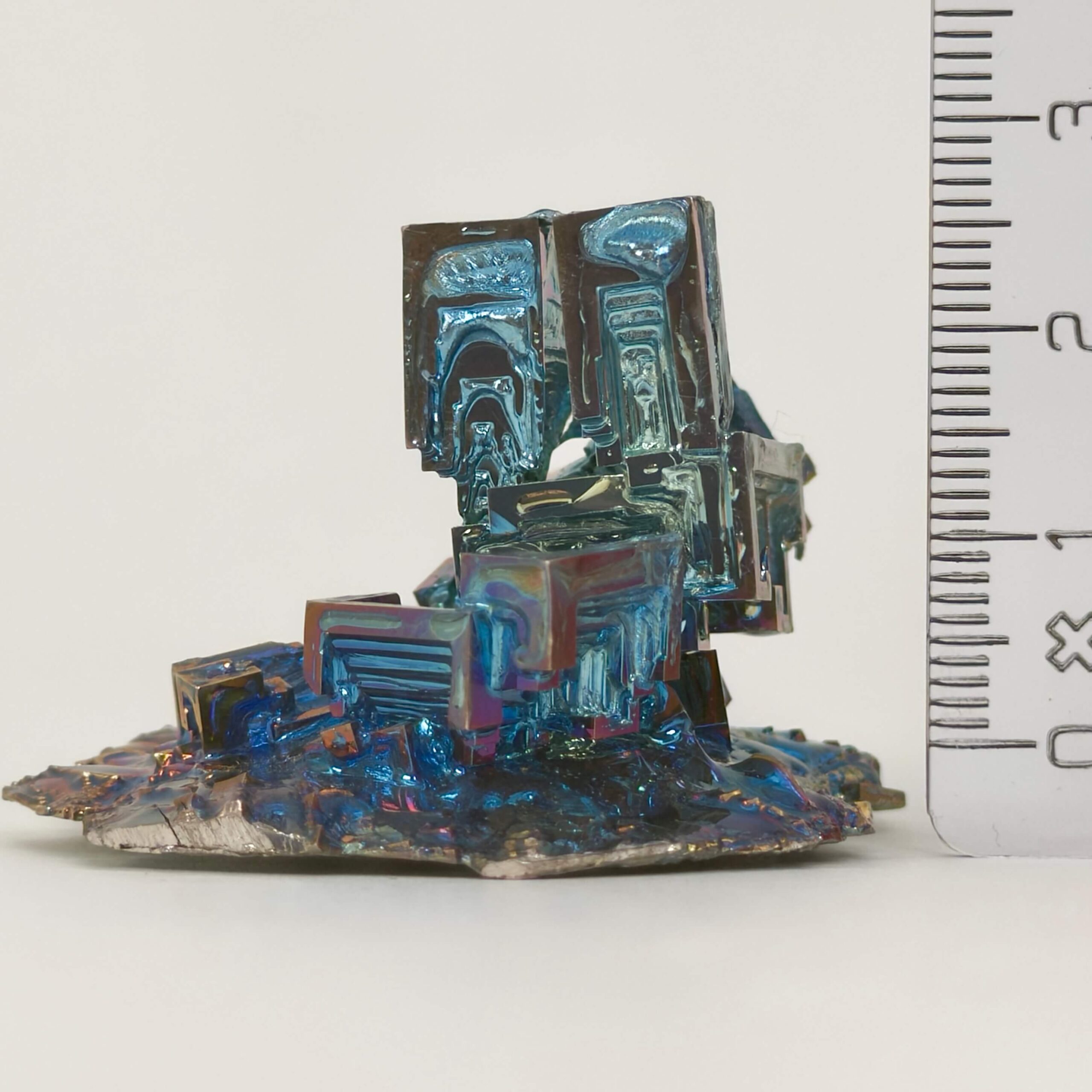 Bismut Rå Krystal Sten med lineal på hvid baggrund