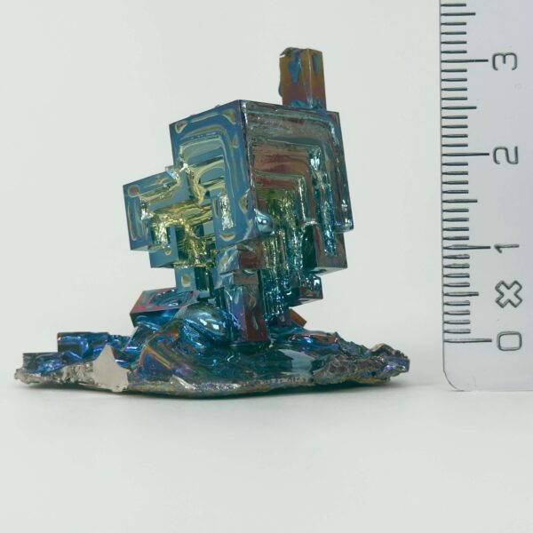 Bismut Rå Krystal Sten med lineal på hvid baggrund