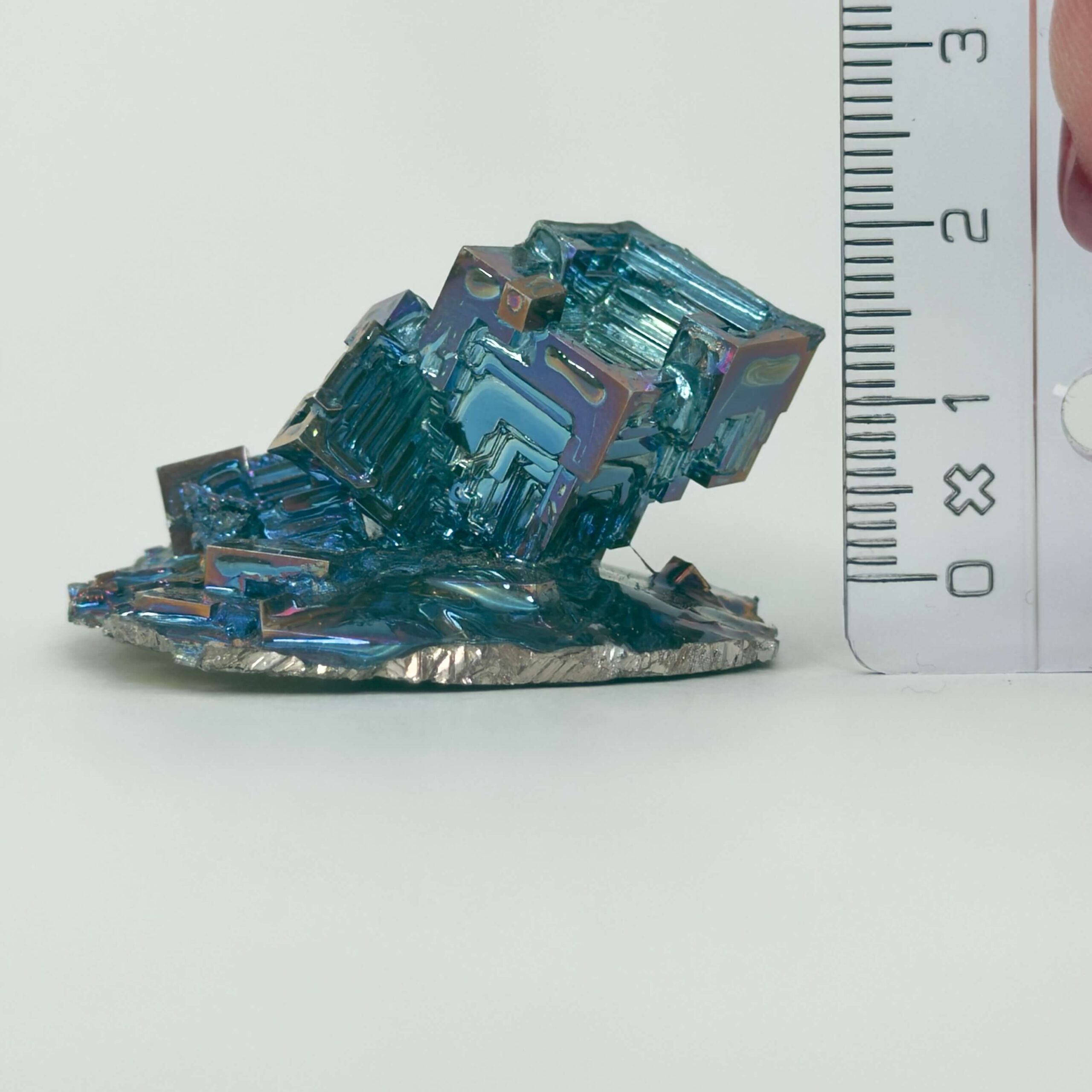 Bismut Rå Krystal Sten med lineal på hvid baggrund