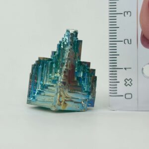 Bismut Rå Krystal Sten med lineal på hvid baggrund