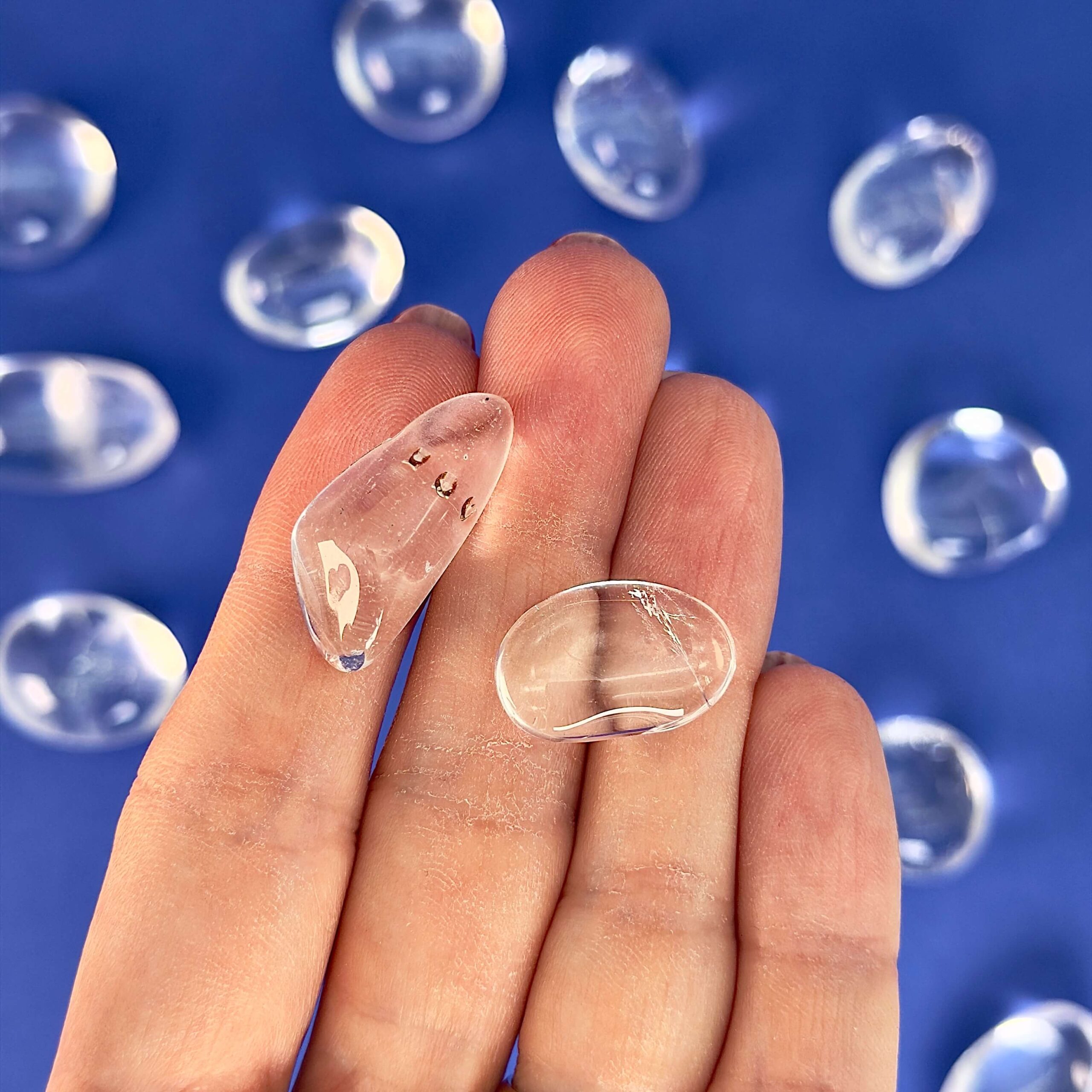 Bjergkrystal Lommesten krystal sten i hånd på blå baggrund