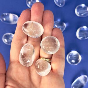 Bjergkrystal Lommesten krystal sten i hånd på blå baggrund