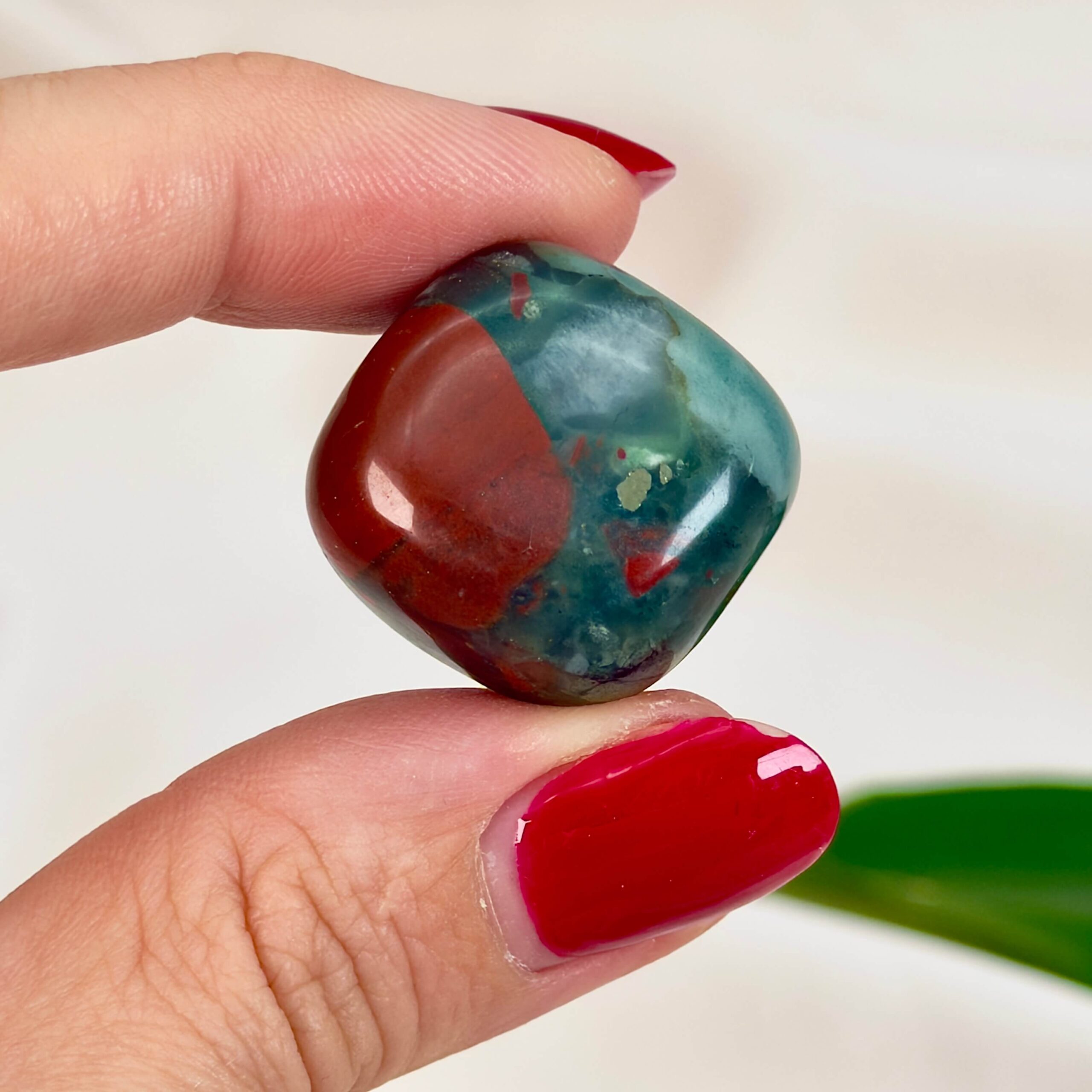 Blodsten Lommesten Krystal Sten i hånd på hvid baggrund