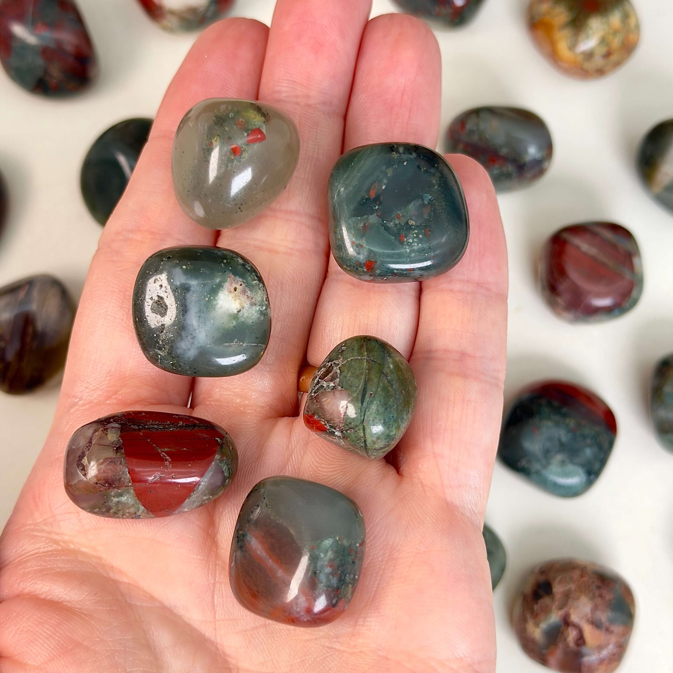 Blodsten Lommesten krystal sten i hånd på hvid baggrund