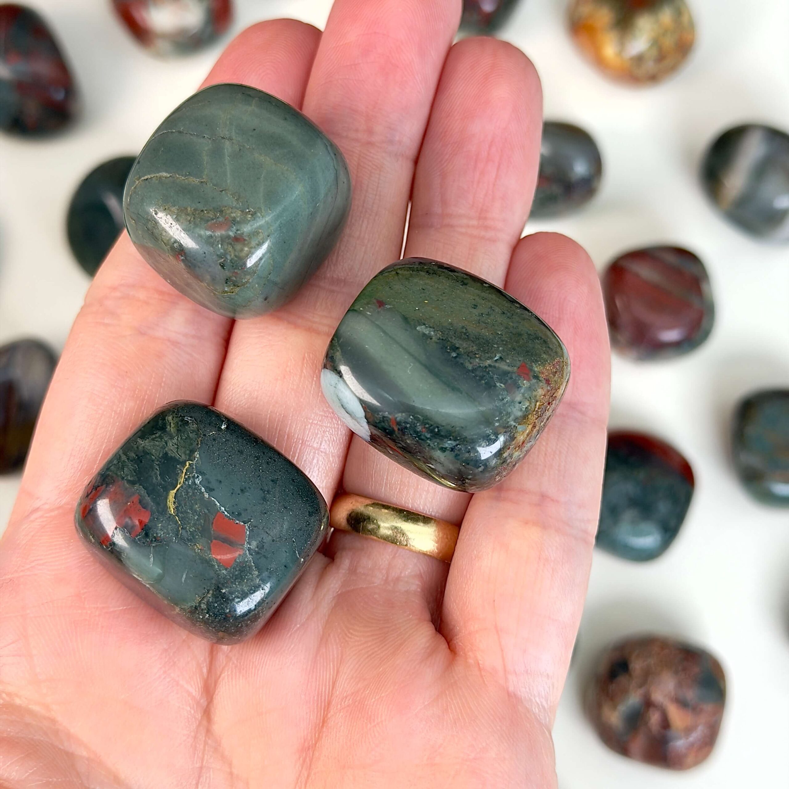 Blodsten Lommesten krystal sten i hånd på hvid baggrund