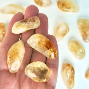 Citrin Lommesten krystal sten i hånd på hvid baggrund