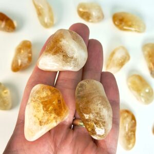 Citrin Lommesten krystal sten i hånd på hvid baggrund