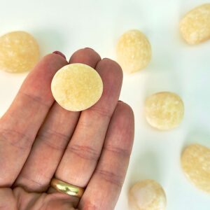 Calsit Gul Lommesten Krystal Sten i hånd på hvid baggrund