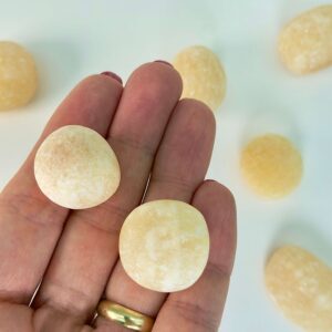 Calsit Gul Lommesten Krystal Sten i hånd på hvid baggrund