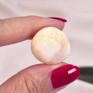 Calsit Gul Lommesten Krystal Sten i hånd på hvid baggrund