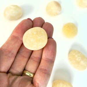 Calsit Gul Lommesten Krystal Sten i hånd på hvid baggrund