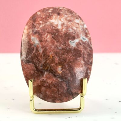 Jordbær Calsit Håndsten Krystal Sten i holder på hvid og lyserød baggrund