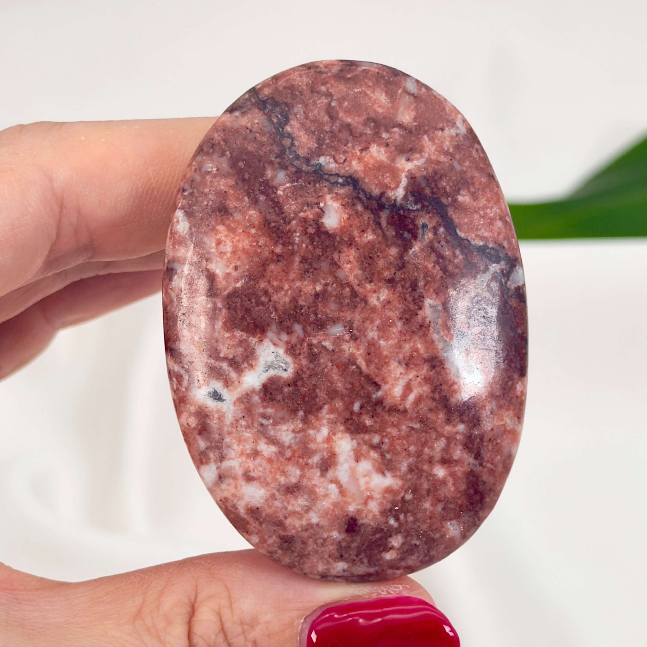 Jordbær Calsit Håndsten Krystal Sten i hånd på hvid baggrund