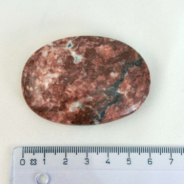 Jordbær Calsit Håndsten Krystal Sten med lineal på hvid baggrund