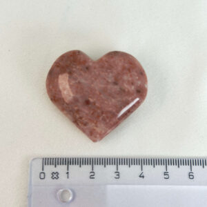 Jordbær Calsit Hjerte Krystal Sten med lineal på hvid baggrund