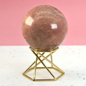 Jordbær Calsit Kugle Krystal Sten på hvid og lyserød baggrund