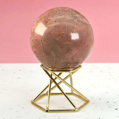 Jordbær Calsit Kugle Krystal Sten på hvid og lyserød baggrund