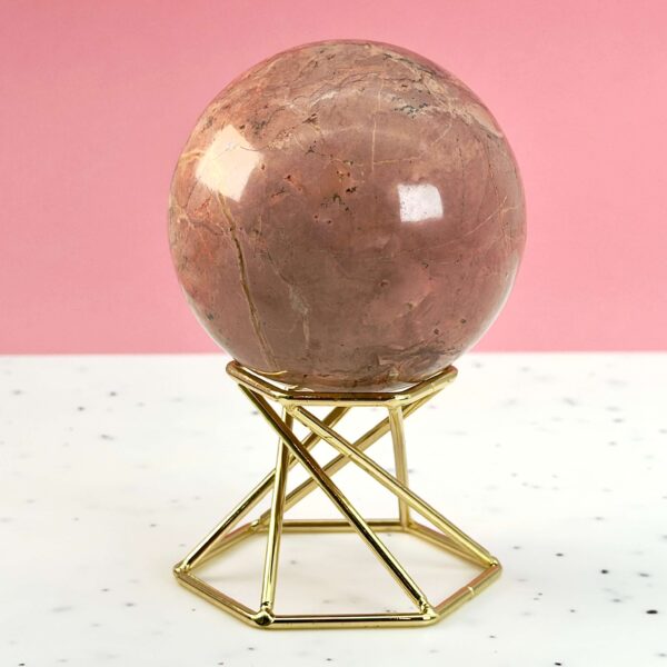 Jordbær Calsit Kugle Krystal Sten på hvid og lyserød baggrund