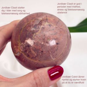 Jordbær Calsit Kugle Krystal Sten i hånd på hvid baggrund med tags