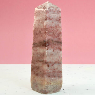 Jordbær Calsit Tårn Krystal Sten på hvid og lyserød baggrund