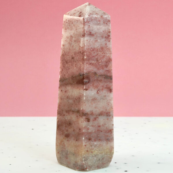 Jordbær Calsit Tårn Krystal Sten på hvid og lyserød baggrund