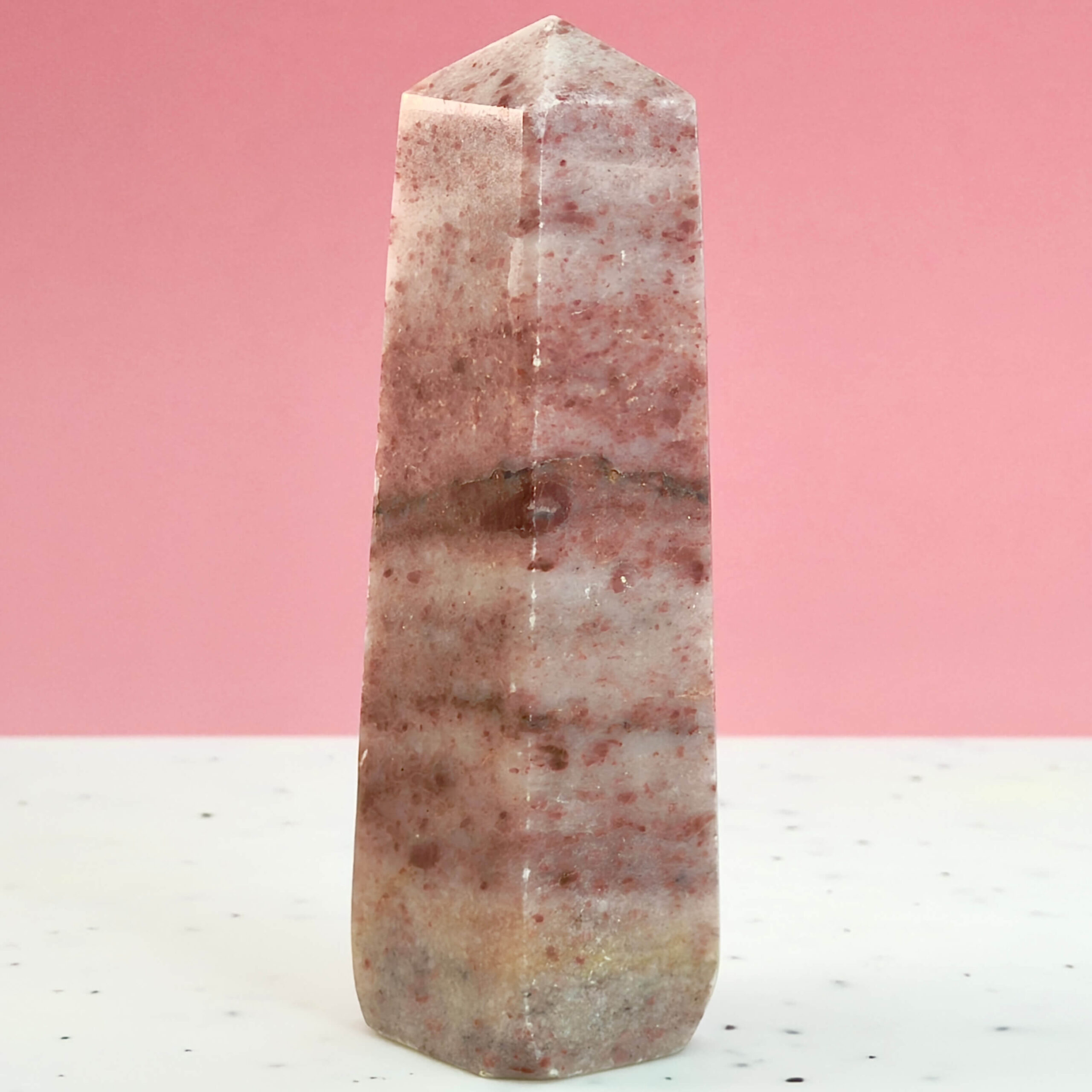 Jordbær Calsit Tårn Krystal Sten på hvid og lyserød baggrund