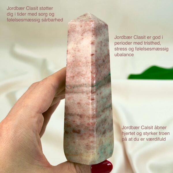 Jordbær Calsit Tårn Krystal Sten i hånd på hvid baggrund med tags