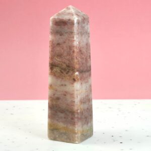 Jordbær Calsit Tårn Krystal Sten på hvid og lyserød baggrund