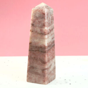 Jordbær Calsit Tårn Krystal Sten på hvid og lyserød baggrund