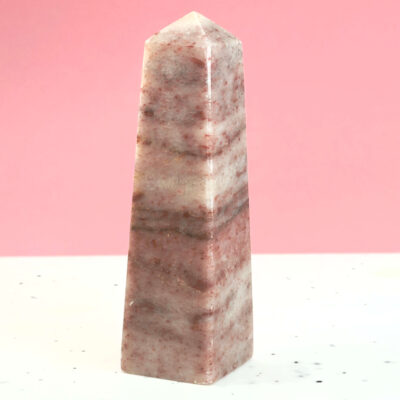 Jordbær Calsit Tårn Krystal Sten på hvid og lyserød baggrund