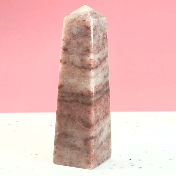 Jordbær Calsit Tårn Krystal Sten på hvid og lyserød baggrund