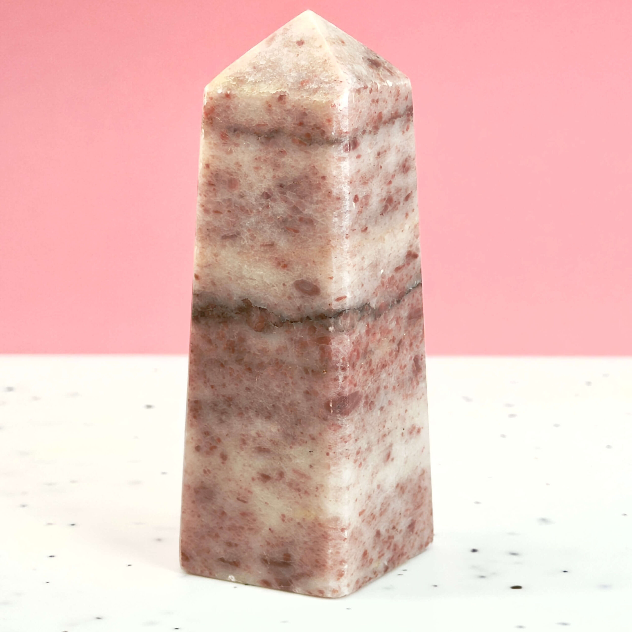 Jordbær Calsit Tårn Krystal Sten på hvid og lyserød baggrund