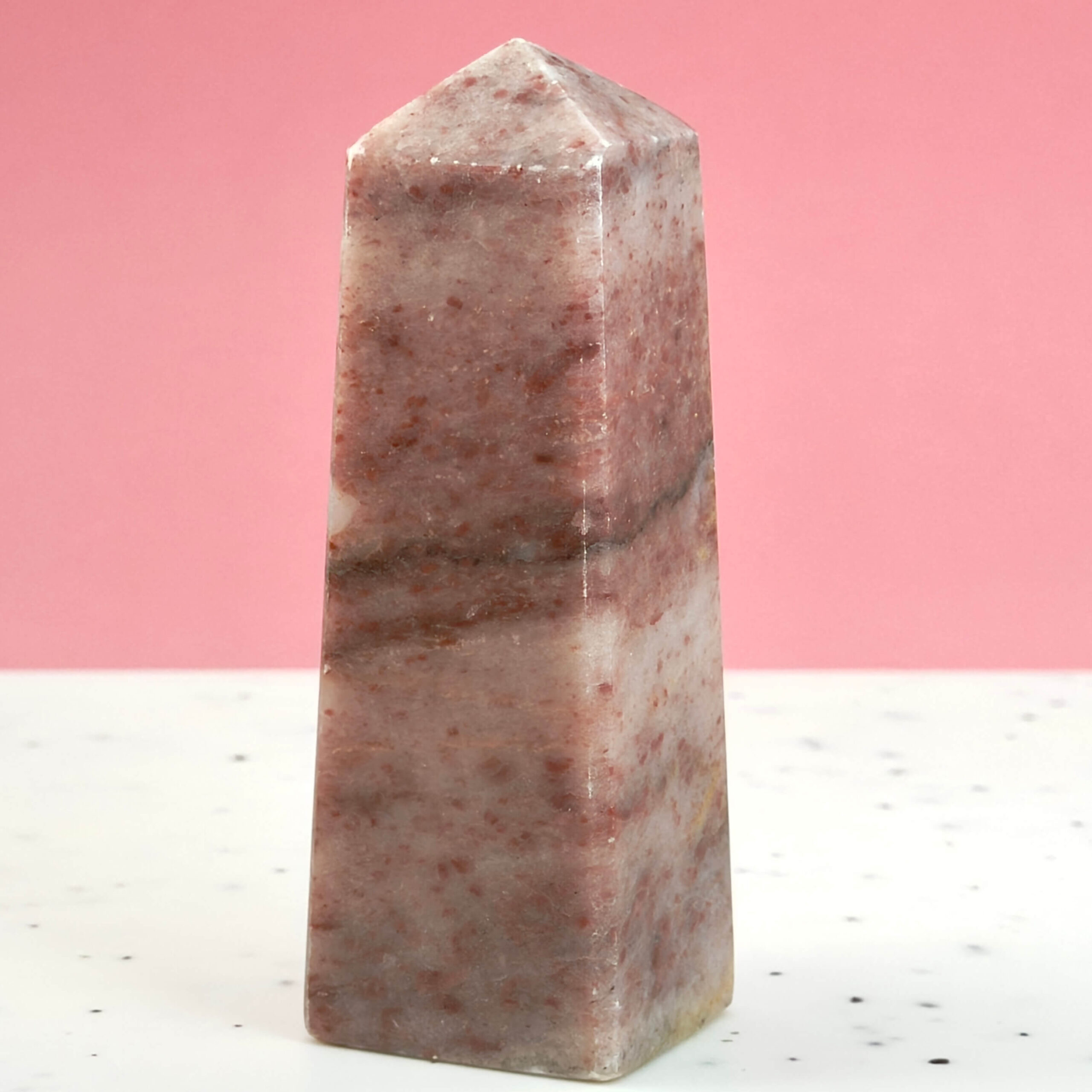 Jordbær Calsit Tårn Krystal Sten på hvid og lyserød baggrund