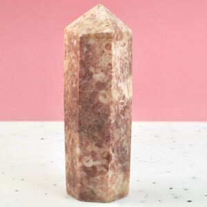 Jordbær Calsit Tårn Krystal Sten på hvid og lyserød baggrund