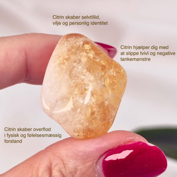 Citrin Brændt lommesten krystal sten i hånd på hvid baggrund med tags