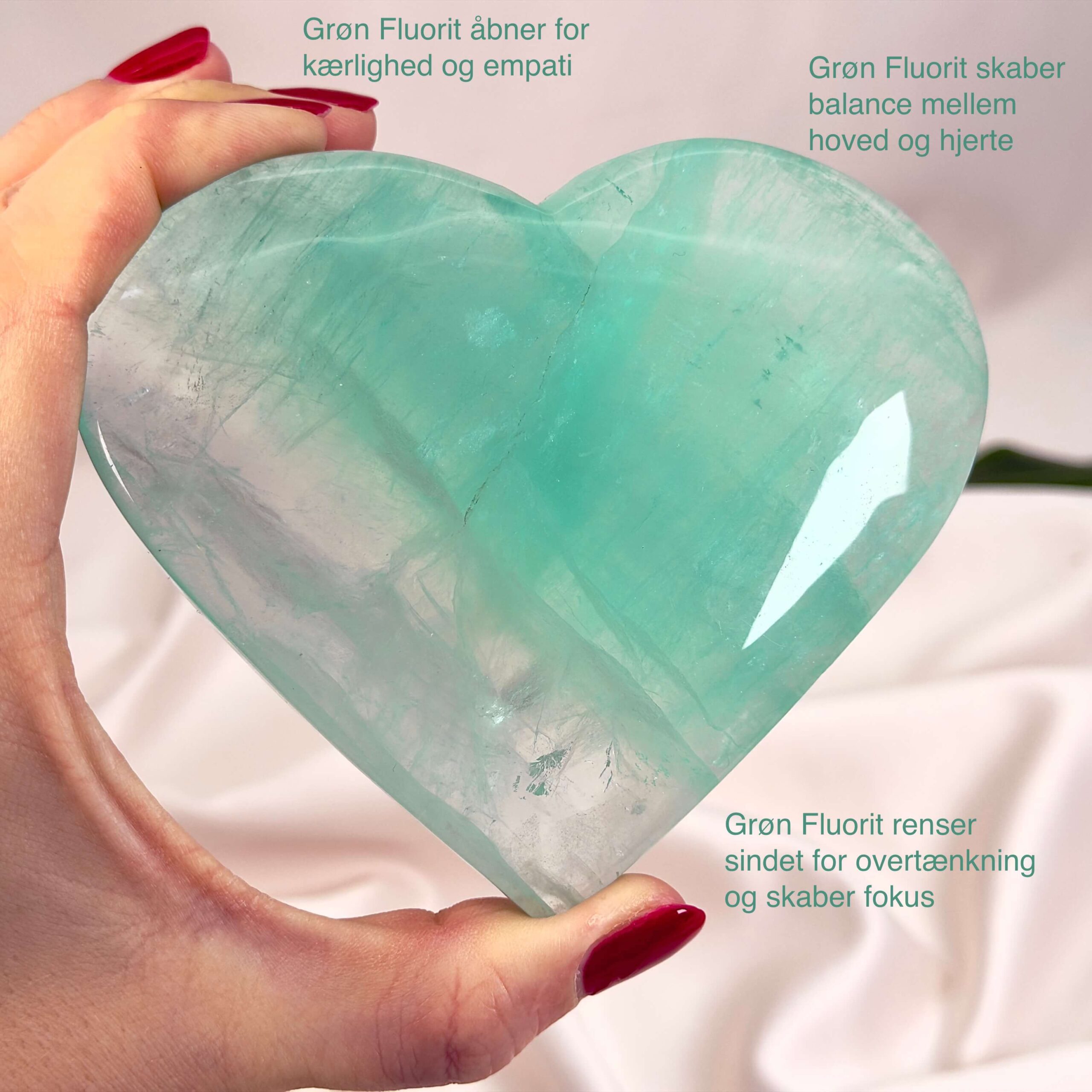 Fluorit Grøn Hjerte Krystal Sten i hånd hvid baggrund med tags